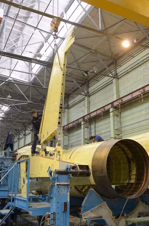 Hệ thống cần cẩu hỗ trợ nhân viên này lắp cánh đuôi đánh chiếc Su-34.