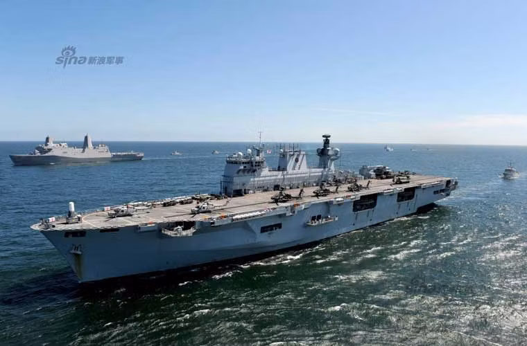 Trong ảnh là tàu đổ bộ lớn HMS Ocean của Hải quân Hoàng gia Anh tham gia tập trận BALTOPS trên biển Baltic. Đi ngay bên cạnh nó (góc trái) là tàu đổ bộ lớp San Antonio của Hải quân Mỹ.