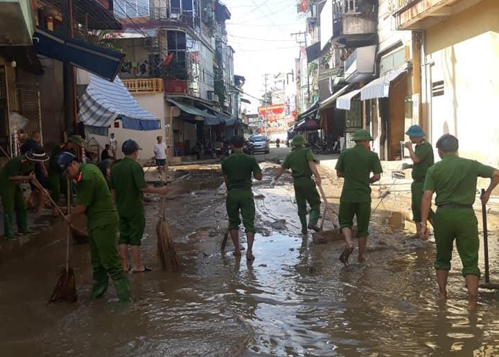Các chiến sĩ cùng người dân dọn dẹp, thông cống, dọn đường do bị ngập úng kéo dài nhiều ngày.