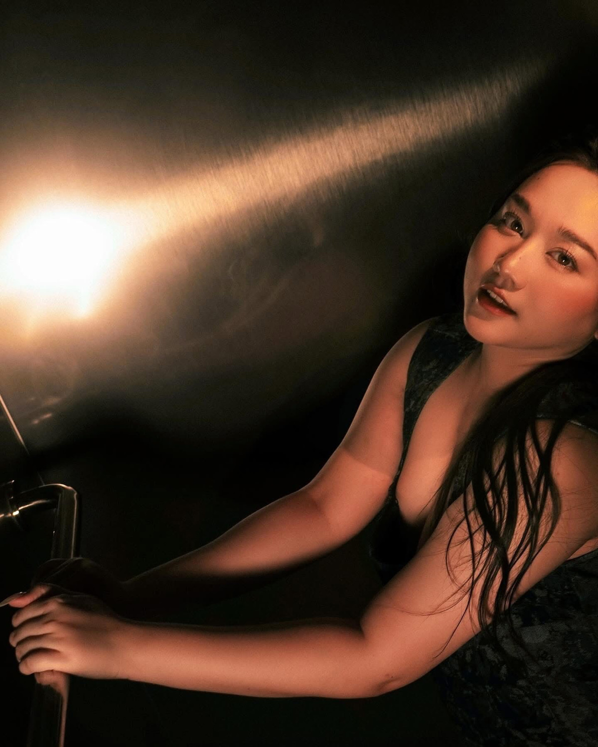 Khung cảnh chụp hình với ánh sáng lạnh, kim loại và hiệu ứng đèn flash tạo nên cảm giác như một thước phim noir – nơi Trúc Anh hiện lên không còn là một “nàng thơ” bị bó buộc, mà là một người phụ nữ dám đối mặt với sự thay đổi và làm chủ hình ảnh của mình.