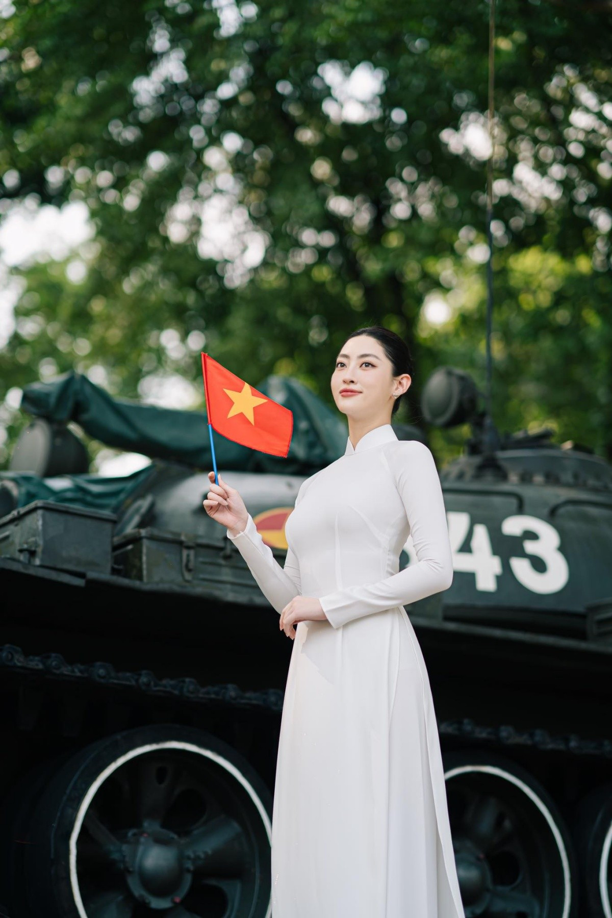 Miss World Vietnam 2019 Lương Thùy Linh lựa chọn tà áo dài trắng thướt tha, cờ tổ quốc và nón lá, nàng hậu chụp cùng chiếc xe tăng huyền thoại.