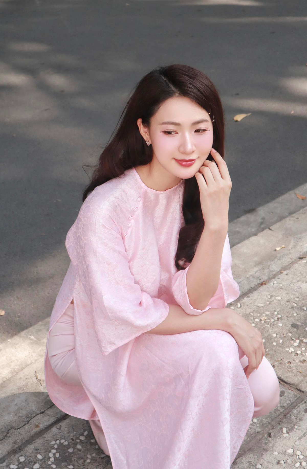 Khoảnh khắc Minh Trang ngồi khẽ nghiêng mình bên vệ đường, ánh nắng nhẹ nhàng rọi xuống, tạo nên một bức tranh đẹp như mơ, đậm chất thơ. Nhiều người hâm mộ dành lời khen "có cánh" cho nhan sắc trong trẻo và thần thái cuốn hút tự nhiên của cô.