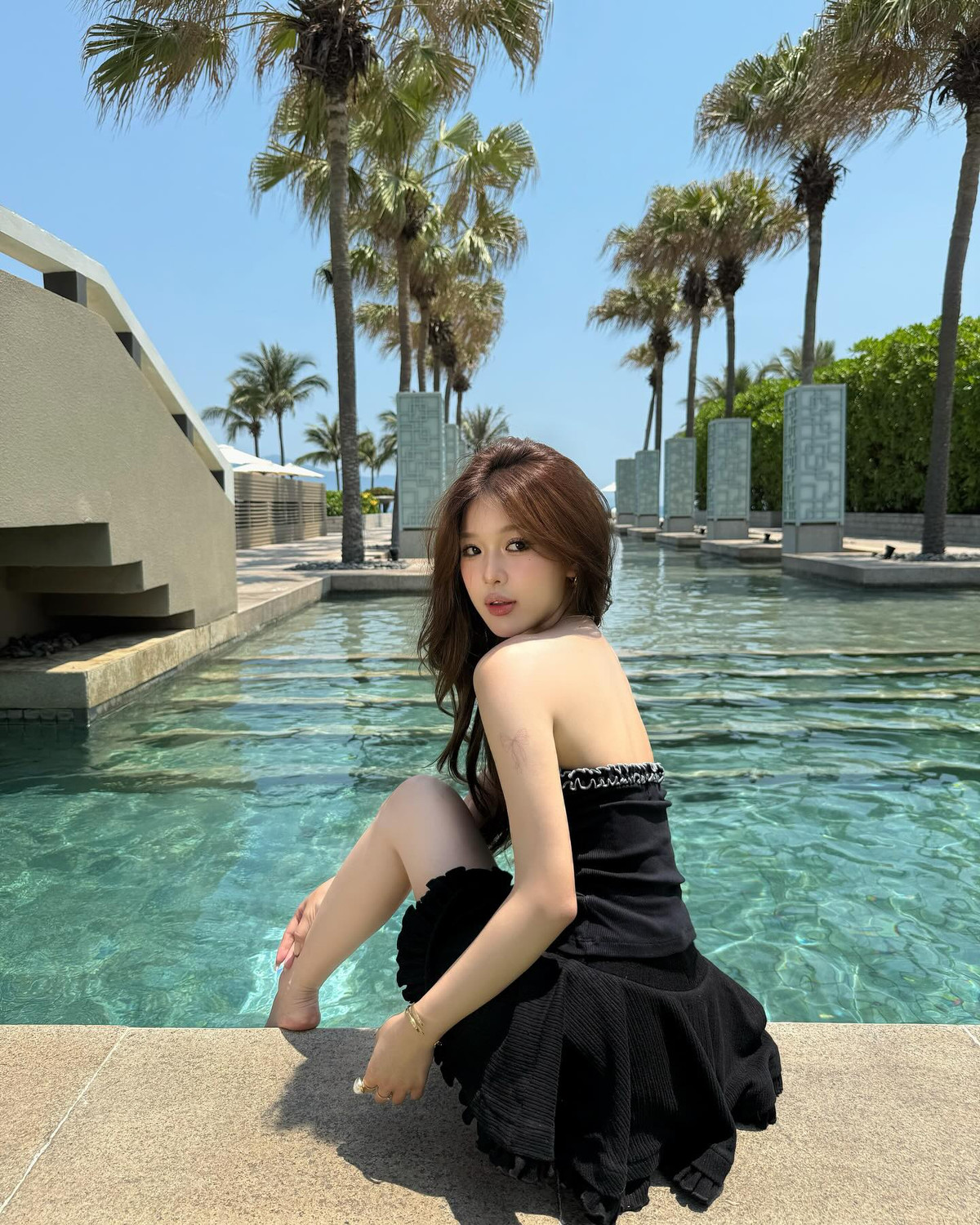 Thiết kế đơn giản nhưng không kém phần tinh tế, với điểm nhấn là chi tiết bèo nhún nhẹ nhàng ở viền ngực và chân váy, mang lại vẻ nữ tính và duyên dáng.