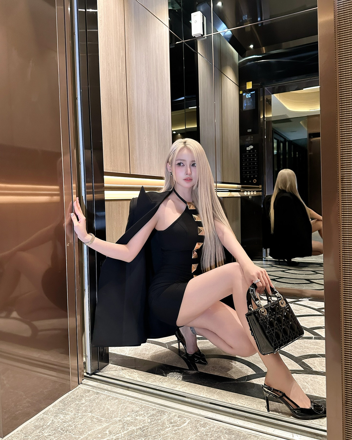 Mái tóc bạch kim duỗi thẳng, lớp trang điểm sắc sảo cùng loạt phụ kiện đắt giá như túi Dior, đồng hồ kim cương… tạo nên một tổng thể không thể rời mắt.