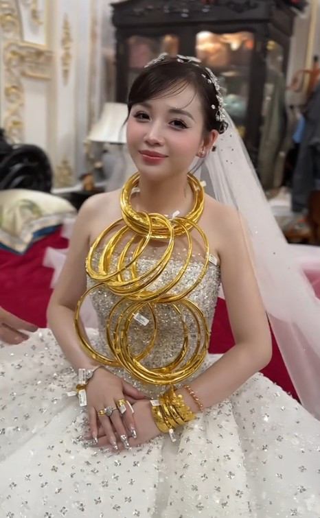 Cô dâu đeo vàng trĩu cổ là Nguyễn Thị Thùy Trang (SN 1994, quê Thanh Hóa). Chồng Thùy Trang là Lê Nam. Hai bên gia đình ở cách nhau 2km, chung 1 khu phố. (Ảnh: Chau Toc Nau)