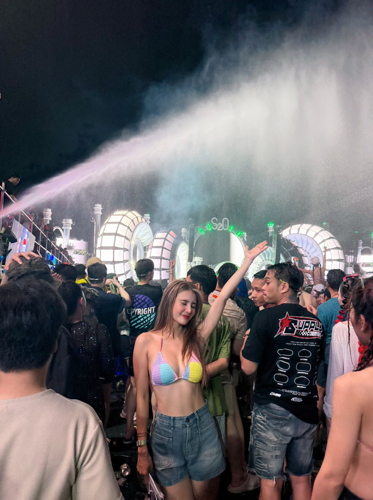 Điểm nhấn lớn nhất trong outfit của Khánh Chi chính là chiếc áo bra crochet với thiết kế tam giác cổ điển, được phối màu pastel nhẹ nhàng nhưng vô cùng nổi bật giữa ánh đèn neon và làn nước lung linh.