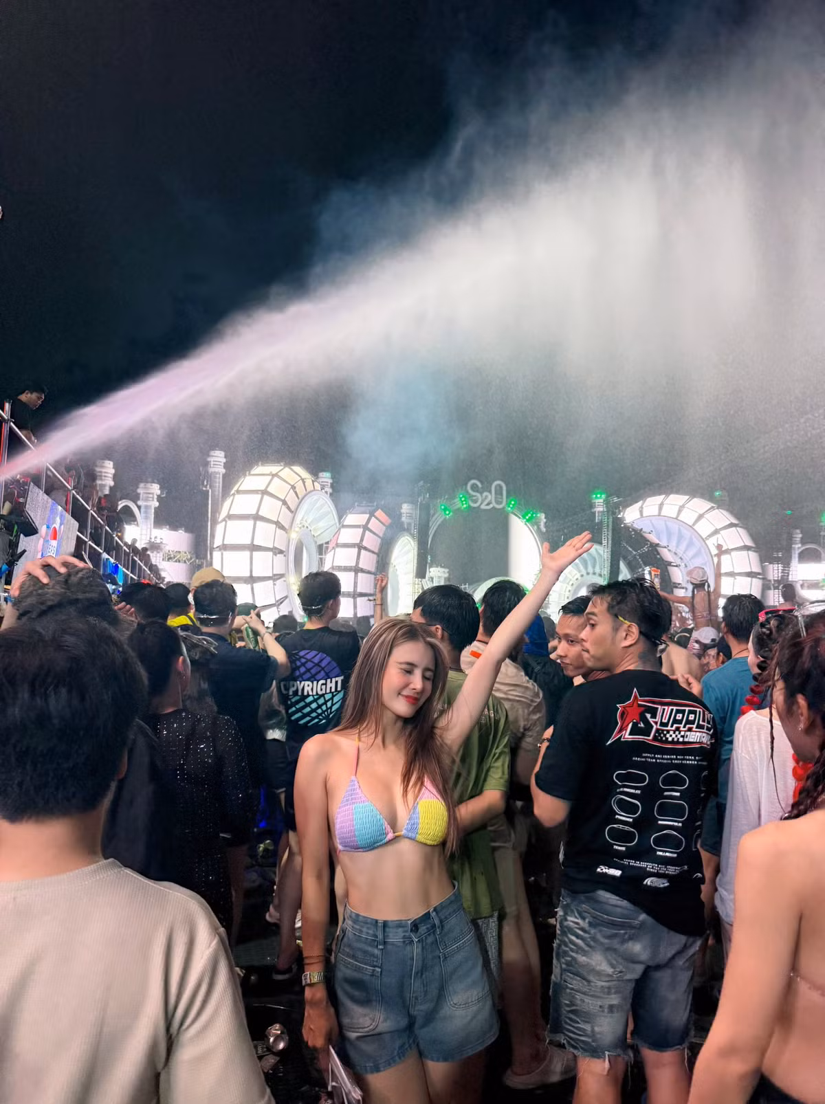 Điểm nhấn lớn nhất trong outfit của Khánh Chi chính là chiếc áo bra crochet với thiết kế tam giác cổ điển, được phối màu pastel nhẹ nhàng nhưng vô cùng nổi bật giữa ánh đèn neon và làn nước lung linh.