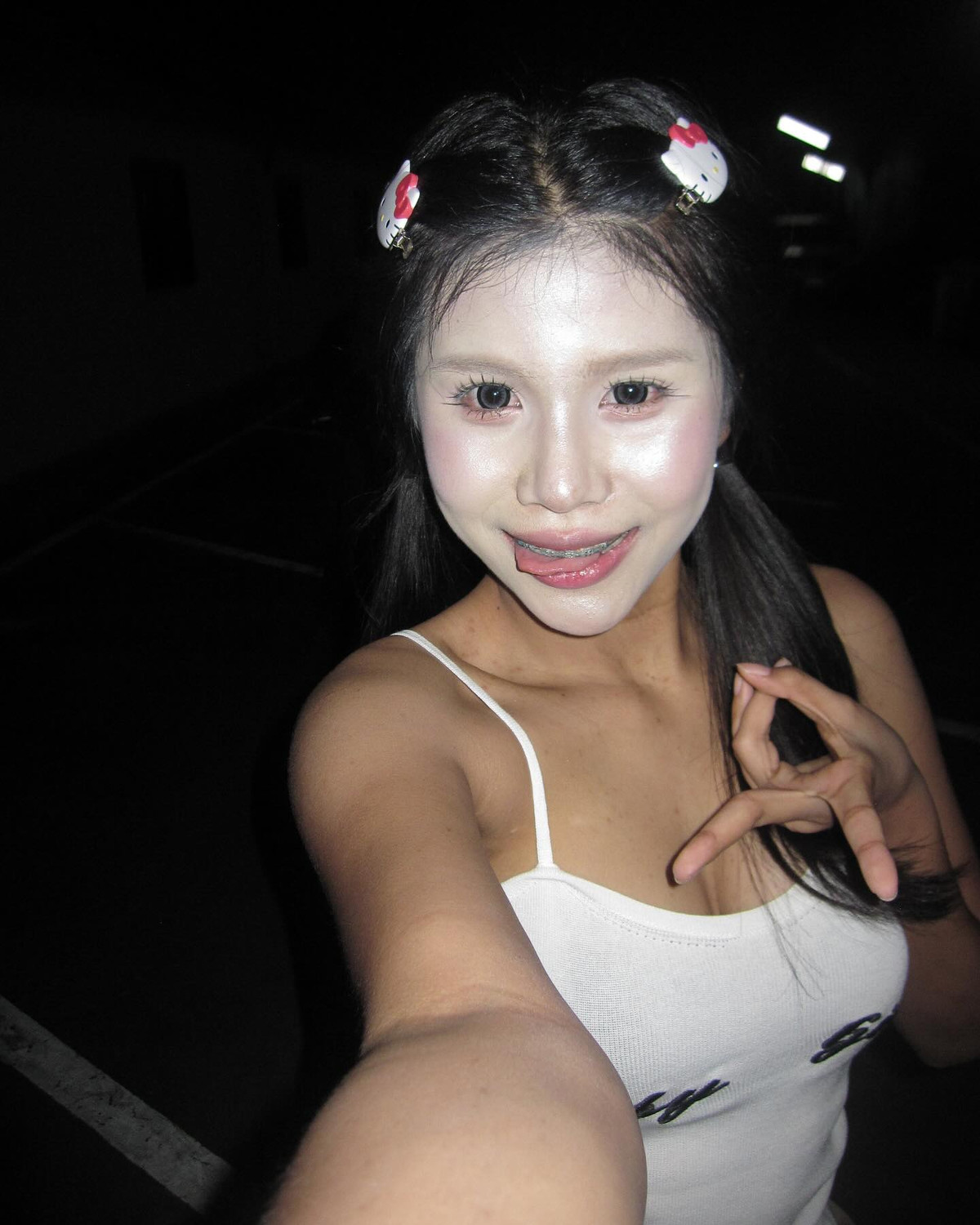 Điểm nhấn không thể không kể đến là hai chiếc kẹp tóc hình Hello Kitty, tạo cảm giác vừa đáng yêu… vừa hơi rùng mình vì tổng thể quá “độc lạ”.