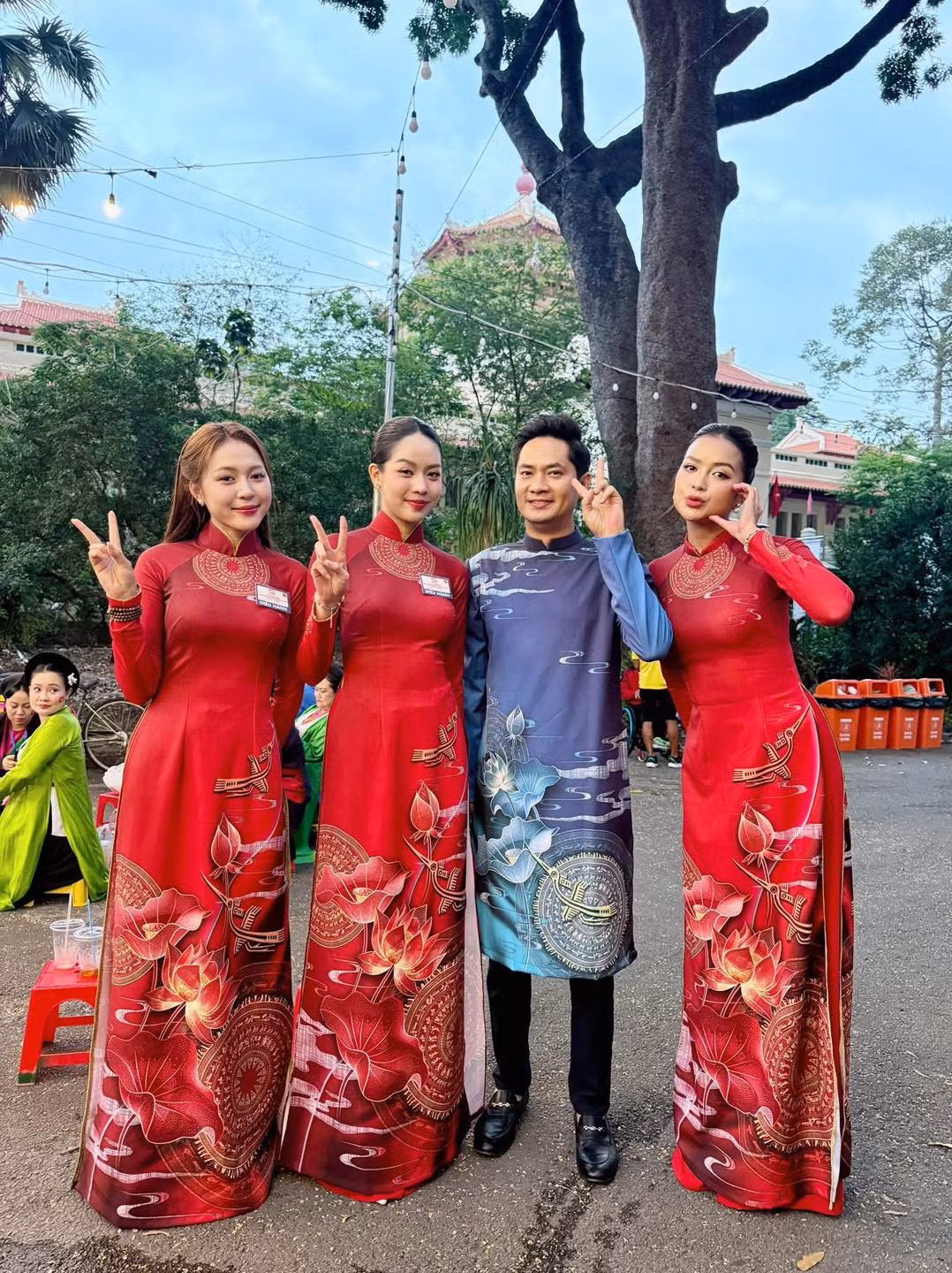 Hoa hậu Thanh Thủy, Ngọc Châu diện áo dài đỏ, tranh thủ check-in trước giờ diễu binh, diễu hành.