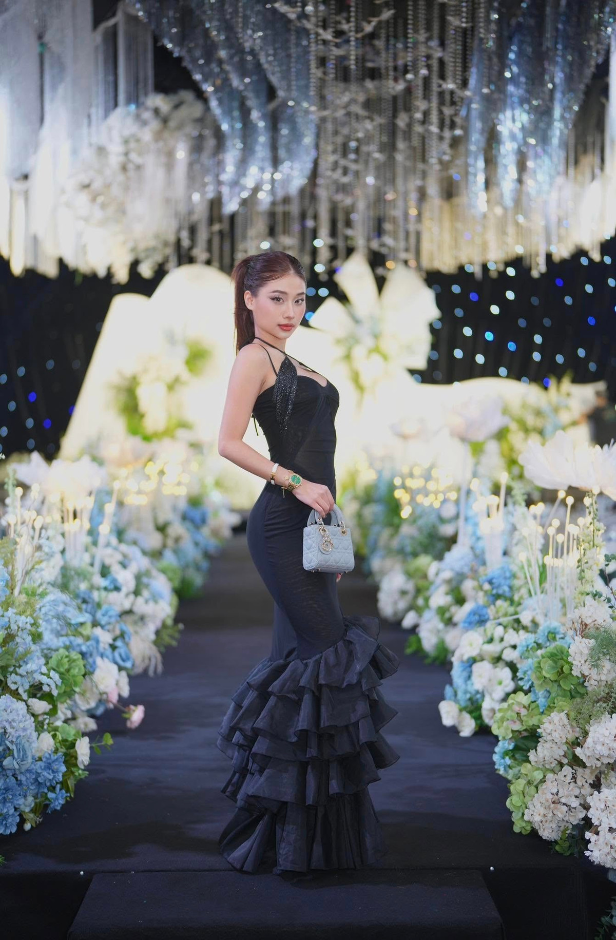 Chiếc đầm đen ôm sát, chất liệu mỏng nhẹ khoe trọn vòng eo thon gọn cùng vòng một nóng bỏng sau khi nâng cấp nhan sắc khiến Louis trở thành tâm điểm của đám cưới.