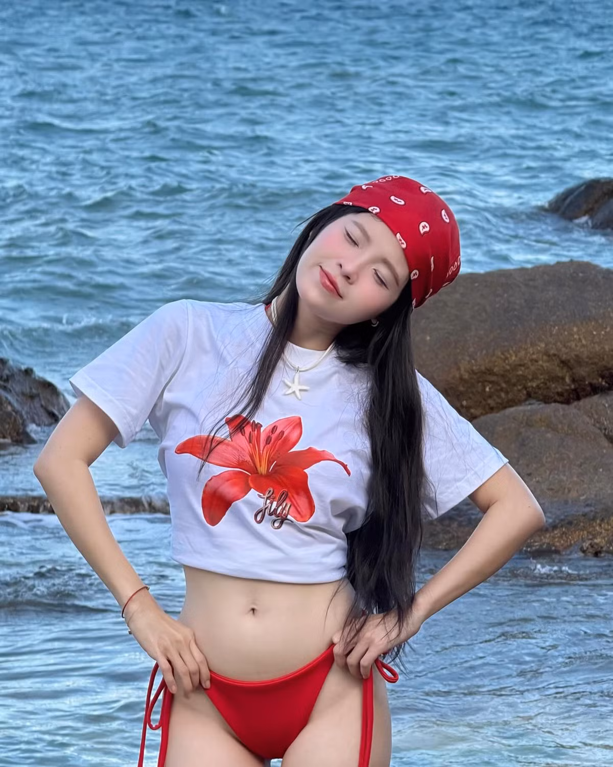 Trong bộ outfit mix giữa áo thun croptop in hình hoa lily nổi bật và bikini đỏ rực, Thúy Kiều khiến dân tình không thể rời mắt.