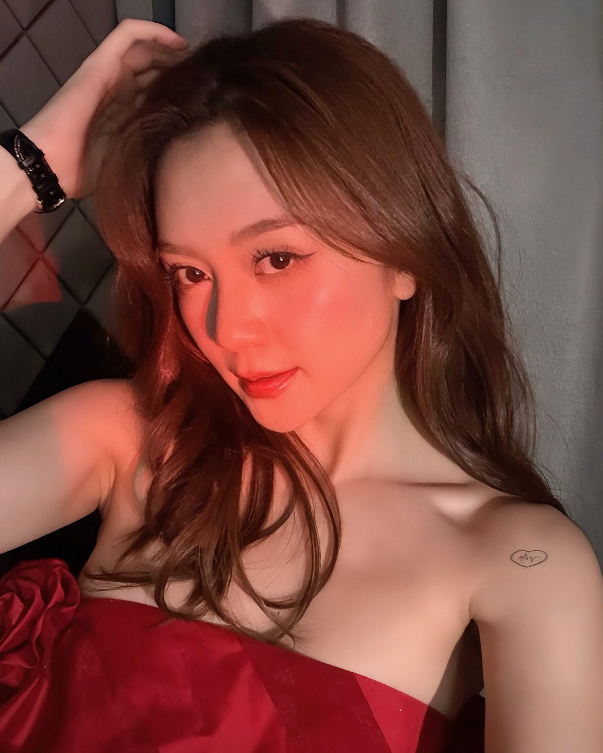 Cô nàng diện chiếc đầm cúp ngực màu đỏ rượu vang – thiết kế đơn giản nhưng cực kỳ táo bạo. Phom dáng ôm sát tôn lên phần xương quai xanh gợi cảm, làn da trắng mịn và bờ vai mảnh mai đầy thu hút. Gam màu đỏ không chỉ làm nổi bật làn da, mà còn góp phần tăng thêm vẻ quyến rũ, quý phái cho tổng thể diện mạo.