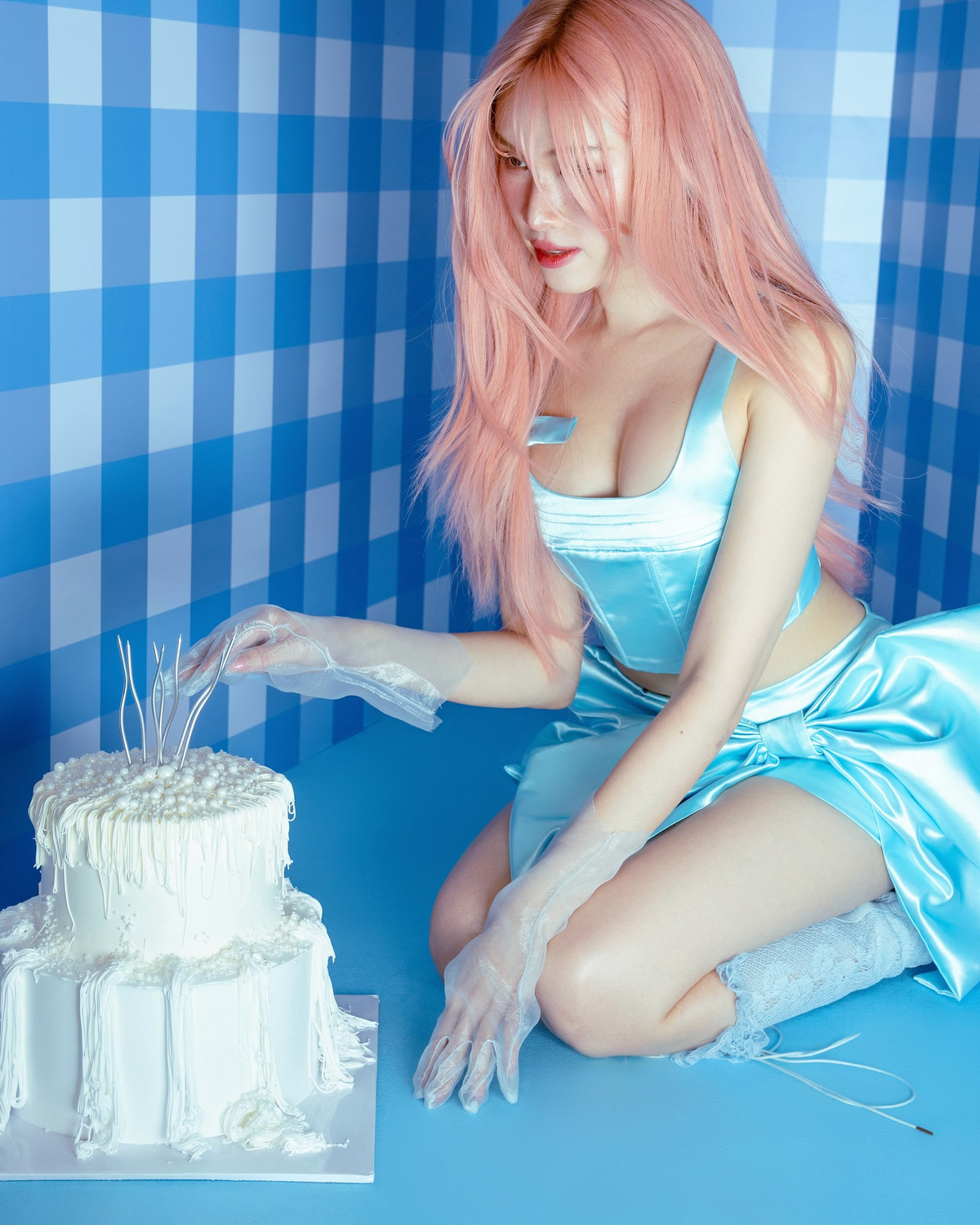 Trong một bức ảnh, cô ngồi bên chiếc bánh kem trắng muốt phủ ngọc trai, đeo găng tay xuyên thấu – gợi cảm nhưng vẫn giữ nét thanh lịch rất riêng.