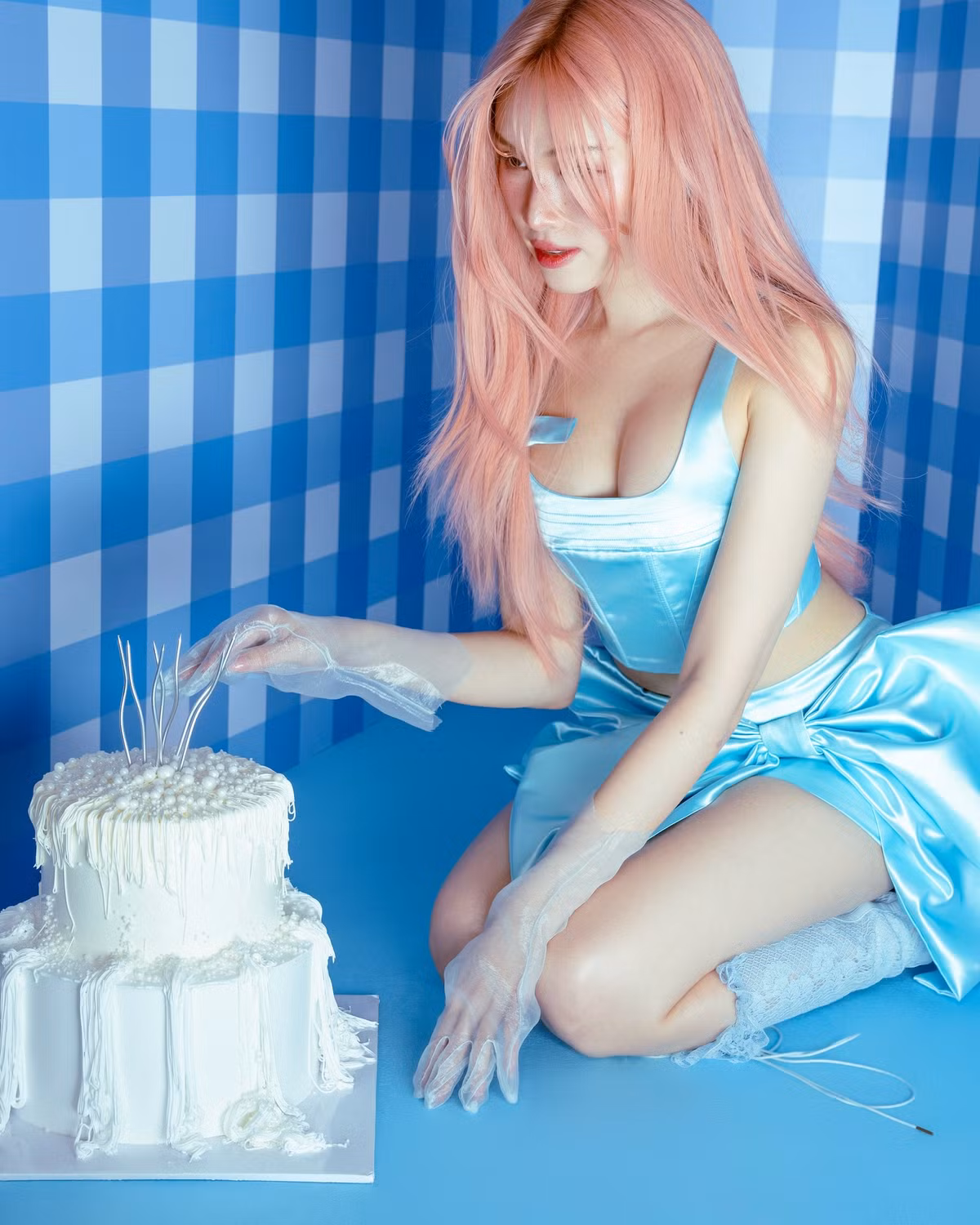 Trong một bức ảnh, cô ngồi bên chiếc bánh kem trắng muốt phủ ngọc trai, đeo găng tay xuyên thấu – gợi cảm nhưng vẫn giữ nét thanh lịch rất riêng.