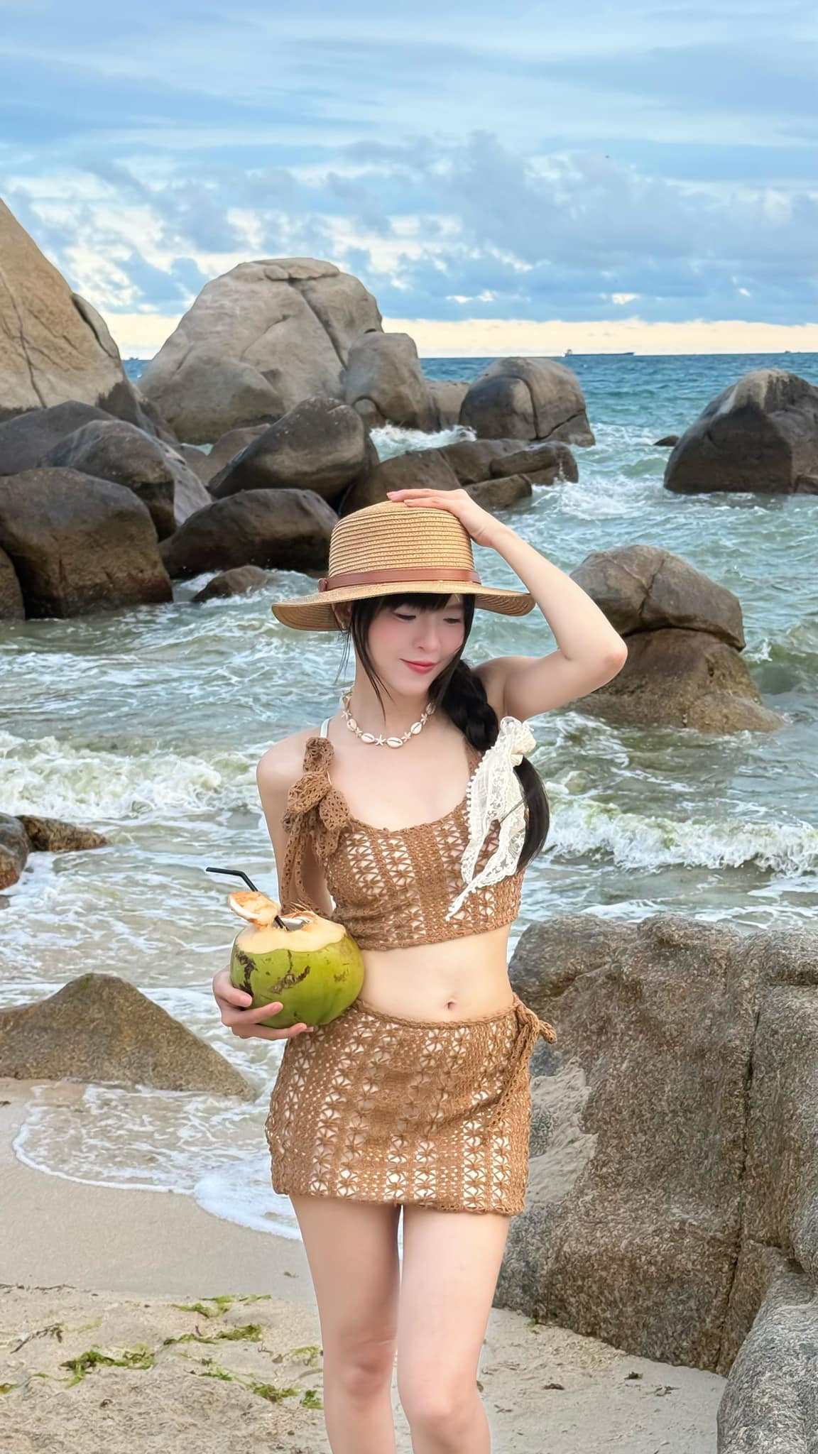 Thúy Kiều chọn cho mình một bộ trang phục crochet (len móc) hai mảnh, gồm áo crop top và chân váy mini đồng bộ. Đây là xu hướng đang “làm mưa làm gió” trong thời trang biển những năm gần đây vừ-a mộc mạc, gần gũi, lại vừa gợi cảm đúng chừng mực.