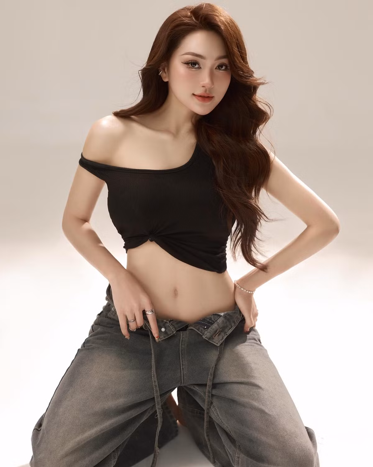 Chiếc áo crop top đen lệch vai được thiết kế thông minh với những đường cắt khoét đầy nghệ thuật, khéo léo khoe ra vòng eo con kiến, xương quai xanh thanh mảnh cùng bờ vai mềm mại – những điểm vàng trên cơ thể mà bất kỳ cô gái nào cũng mong muốn được sở hữu và tôn vinh.