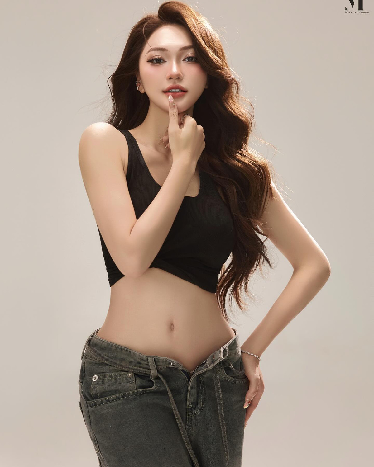 Đi kèm với đó là chiếc quần jeans dáng rộng wash màu xám tro, mang đậm chất đường phố hiện đại. Phần cạp thấp nhẹ không chỉ tôn lên phần hông đầy đặn quyến rũ mà còn cân đối lại sự ôm sát của phần trên, tạo nên tổng thể "high fashion" nhưng vẫn mang chất "nửa bụi, nửa thơ" – rất hợp với nét đẹp của Ngọc Nữ: vừa cá tính, vừa ngọt ngào.