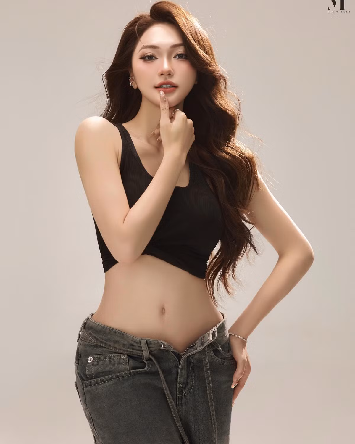 Đi kèm với đó là chiếc quần jeans dáng rộng wash màu xám tro, mang đậm chất đường phố hiện đại. Phần cạp thấp nhẹ không chỉ tôn lên phần hông đầy đặn quyến rũ mà còn cân đối lại sự ôm sát của phần trên, tạo nên tổng thể "high fashion" nhưng vẫn mang chất "nửa bụi, nửa thơ" – rất hợp với nét đẹp của Ngọc Nữ: vừa cá tính, vừa ngọt ngào.