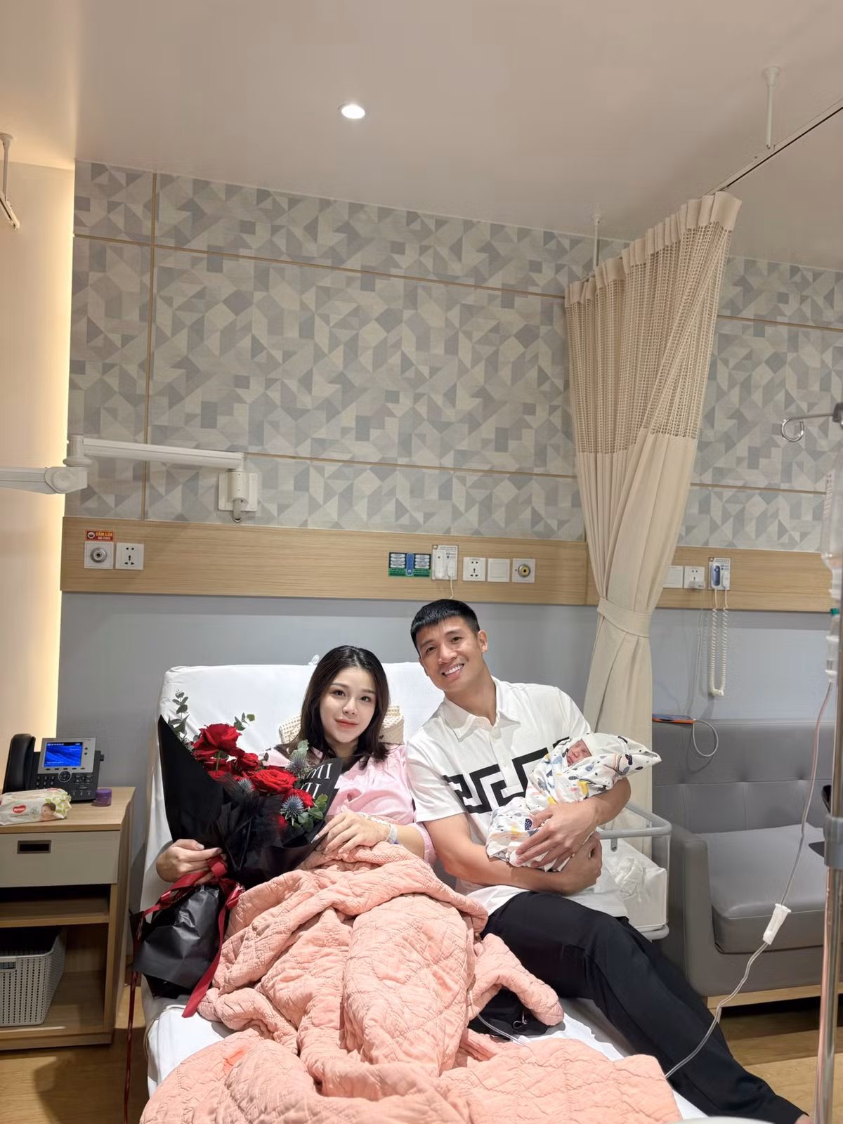 Trong bức ảnh được đăng tải, Bùi Tiến Dũng rạng rỡ ôm bé sơ sinh trong vòng tay, bên cạnh là bà xã Khánh Linh đang ngồi trên giường bệnh, tay cầm bó hoa tươi, cùng hai cô con gái lớn tạo dáng đáng yêu. Gia đình năm người quây quần trong khung cảnh ngập tràn yêu thương, ấm áp và hạnh phúc viên mãn.