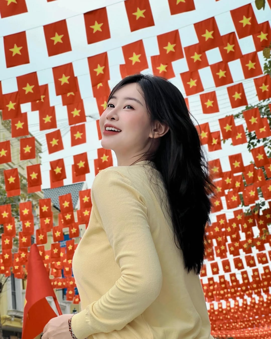 Trong video chia sẻ trên TikTok, Lê Chi hướng dẫn cách tạo dáng chụp ảnh tại con đường treo đầy cờ đỏ sao vàng làm sao để có được thành quả ưng ý nhất.