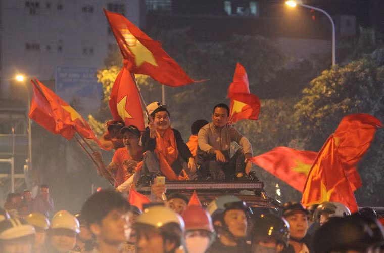 Không chỉ có vậy, vô số người dân còn leo lên nóc các ô tô phất cờ, reo hò.