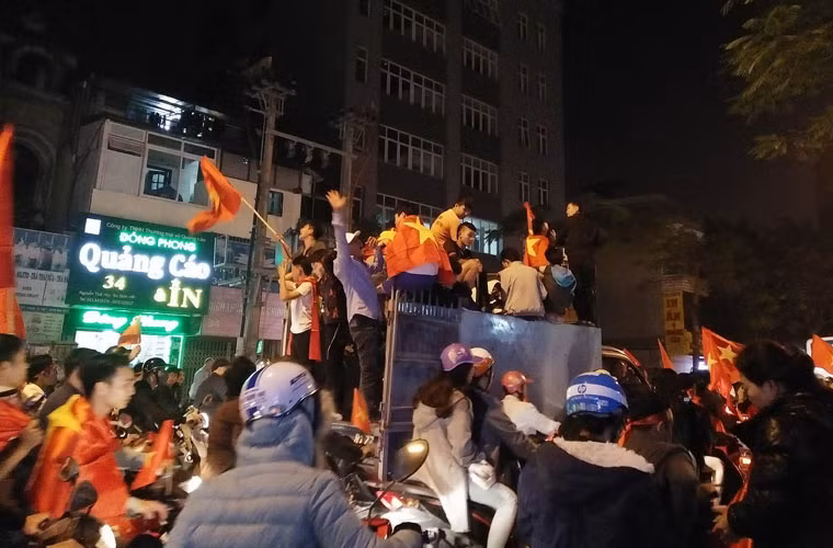 Quanh những chiếc ô tô chở kín người này là dòng xe máy ken đặc. Nếu người ngồi trên xe không may rơi xuống thì dễ xảy ra tai nạn thương vong.