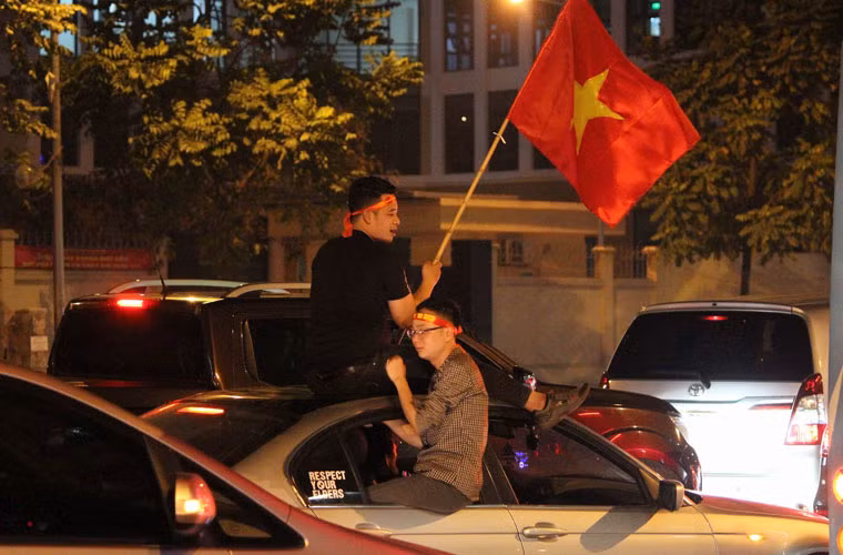 "Chúng tôi quyết, không để tình trạng nhóm thanh niên quán khích, đua xe, gây náo loạn đường phố, nguy hiểm cho mọi người”, Thượng tá Mẽ nói. Trong ảnh, hai thanh niên leo ngồi trên cửa và nóc ô tô giữa dòng xe đông đúc.