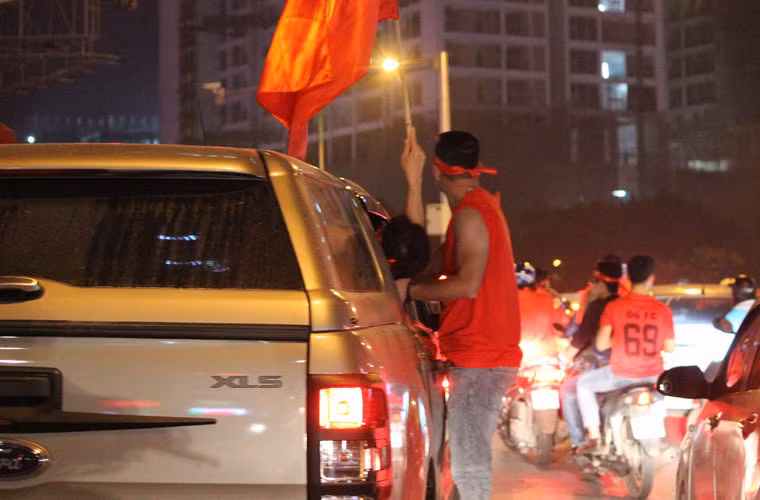 Lực lượng CSCĐ đã tập trung 100% quân số đang làm nhiệm vụ ở các tụ điểm nóng để đảm bảo an ninh, ngăn chặn không để xảy ra đua xe, cổ vũ quá khích... Ảnh: Một thanh niên đu lên cửa ô tô đang di chuyển.