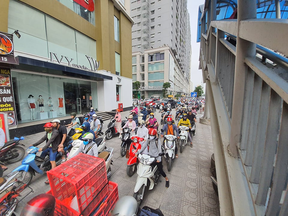 Do đường đã quá đông nên người dân tràn lên vỉa hè để đi.