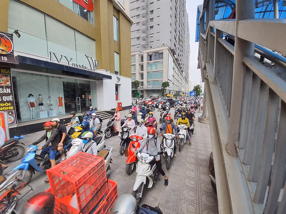 Do đường đã quá đông nên người dân tràn lên vỉa hè để đi.