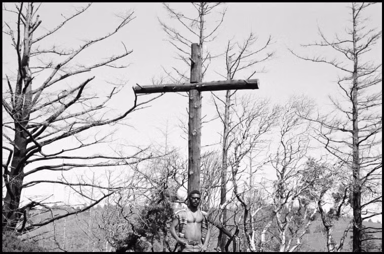 Một "tín đồ" Hippie đứng dưới cây thánh giá tại một khu công xã ở Mỹ năm 1969. Ảnh: Dennis Stock/ Magnum Photos.