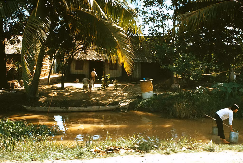 Người phụ nữ lấy nước từ con kênh ở ngoại ô Cần Thơ. Ảnh: William Ruzin.