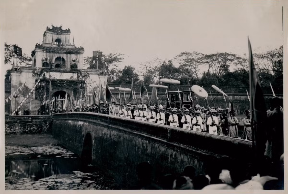 Kiệu của vua Bảo Đại di chuyển qua cầu, hai bên là hai hàng lính mặc sắc phục trắng. Ảnh: Tang-Vinh Photo.