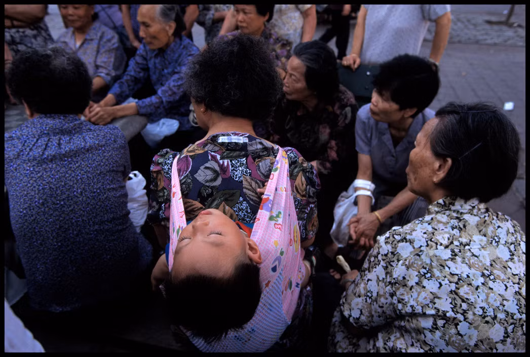 Đám đông tụ tập xem các cụ bà đánh bài ở công viên Columbus. Ảnh: Chien-Chi Chang/ Magnum Photos.