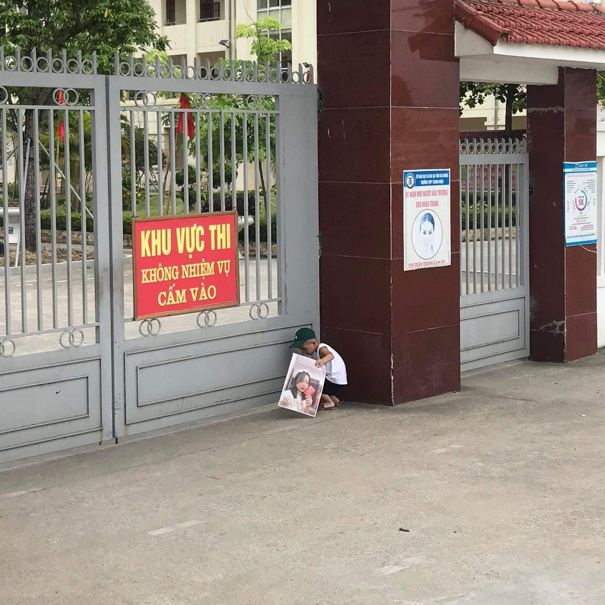 Cậu bé lon ton đứng ngóng chị ở trước cổng trường. Tâm trạng thấp thỏm hệt như một phụ huynh đang chờ mong đứa con của mình hoàn thành bài thi khiến ai nhìn cũng thích thú.