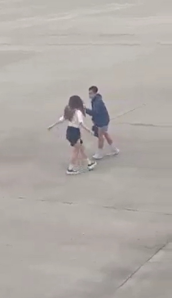 Phía trước còn có một nam thanh niên cầm điện thoại quay clip giúp cô gái. Sau khi quay xong cả hai nhanh chóng rời khỏi bãi đỗ máy bay. Tuy nhiên, sự việc này đã bị một hành khách ngồi trên máy bay chuẩn bị cất cánh ghi lại.