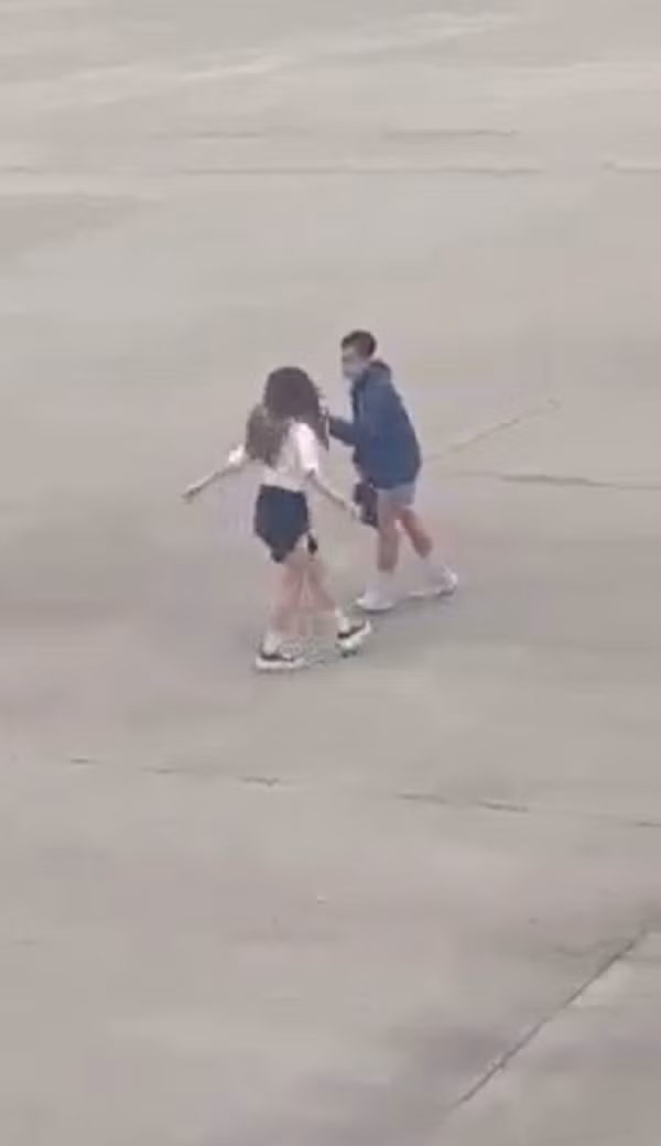 Phía trước còn có một nam thanh niên cầm điện thoại quay clip giúp cô gái. Sau khi quay xong cả hai nhanh chóng rời khỏi bãi đỗ máy bay. Tuy nhiên, sự việc này đã bị một hành khách ngồi trên máy bay chuẩn bị cất cánh ghi lại.