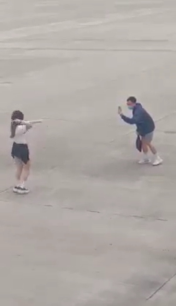 Theo clip được ghi lại cô gái mặc áo phông trắng kết hợp với quần short bò và buộc một chiếc áo sơ mi xuống eo đang nhảy múa ngay trước bãi đỗ máy bay.