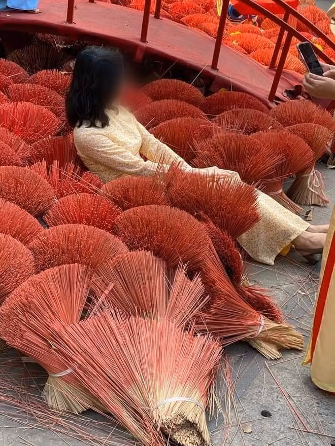 Mới đây, mạng xã hội xôn xao trước hình ảnh ghi lại cảnh 2 người phụ nữ mặc áo dài nằm đè lên những bó hương rồi cười tươi để taọ dáng chụp ảnh.