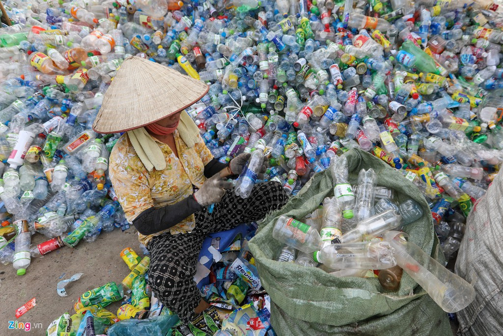 Lao động chính trong làng là những người phụ nữ có độ tuổi trung bình từ 50-70. Dụng cụ bảo hộ lao động của họ chỉ đơn giản là chiếc khẩu trang mỏng và găng tay. Sau khi cắt mác, các vỏ chai sẽ được đưa vào máy nghiền nhỏ để làm nguyên liệu nhựa tái chế.