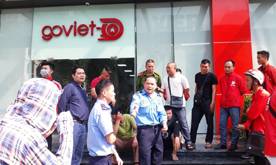 Các tài xế tập trung trước cửa ra vào trụ sở Công ty Go-Viet tại Hà Nội đòi hỏi gặp người đại diện để trình bày nguyện vọng. Tuy nhiên, họ đã bị lực lượng bảo vệ Công ty ngăn lại.