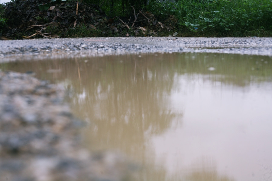 Nước ngập tràn mặt đường khi có mưa lớn, kèm theo những hố sâu tiềm ẩn nhiều nguy cơ tai nạn giao thông chết người. Việc đi lại của người dân nơi đây vô cùng khó khăn bởi "con đường đau khổ" này.