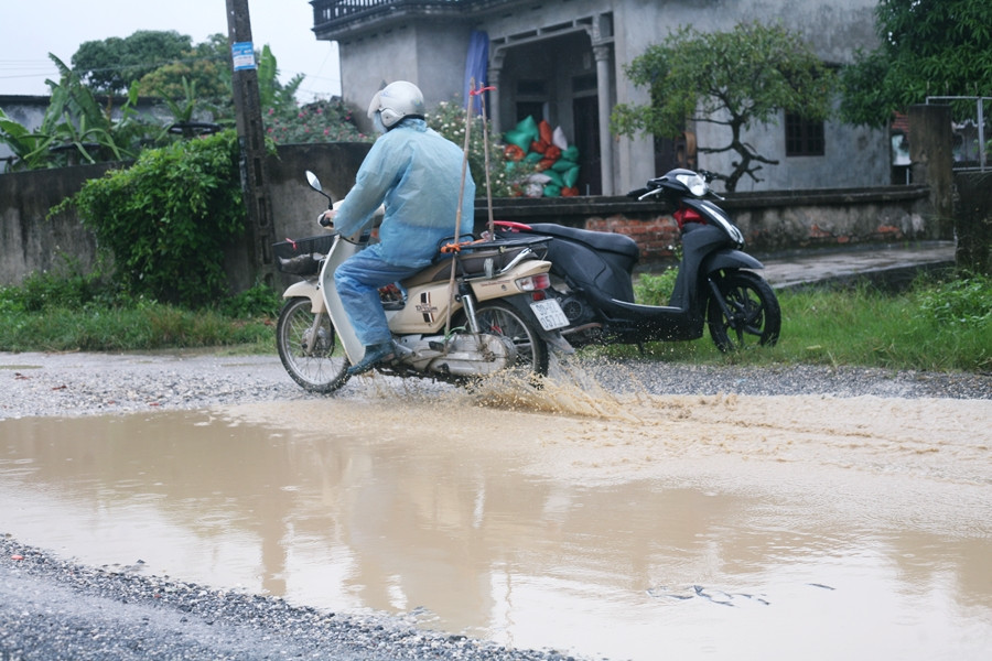 Người dân cố gắng di chuyển sát về phía mép đường nhằm tránh những cái "ao sâu", nhưng không ăn thua.