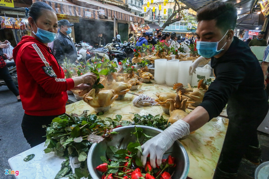 Gà luộc xong được cắt tỉa rồi cắm hoa hồng. Mỗi hàng bày khoảng vài chục con cho khách lựa. 