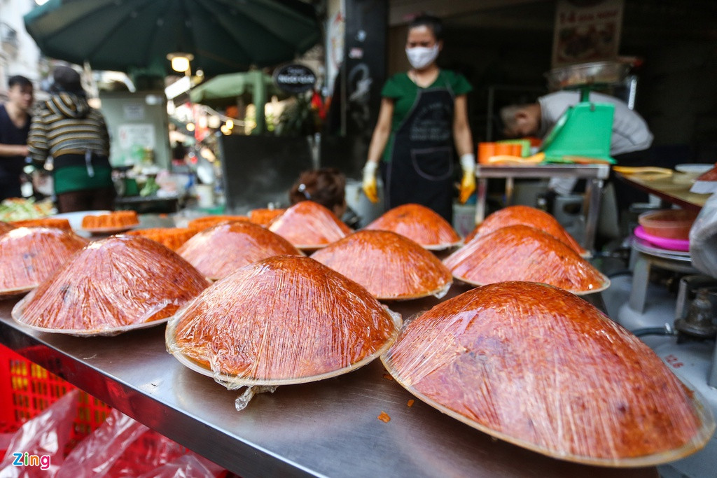 Bên cạnh gà, các mặt hàng đồ ăn khác cũng được bày bán. Xôi gấc có giá 40.000, 60.000 và 100.000 đồng tuỳ kích cỡ.