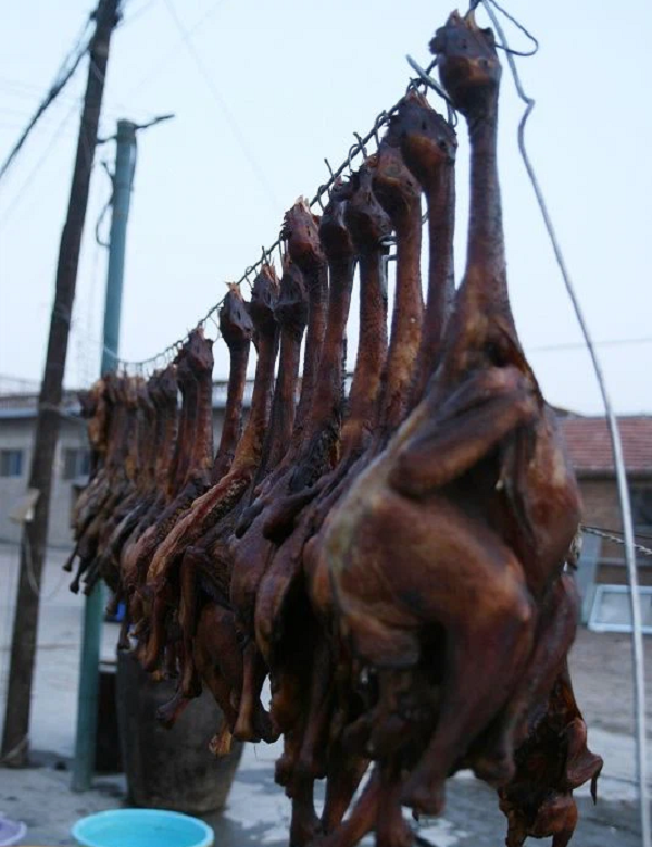 Các loại thảo mộc, muối, gia vị bí truyền sẽ được tẩm ướp vào bên trong con gà một cách nhanh chóng. Sau cùng, người đầu bếp sẽ vặt lông và khéo léo khâu con gà lại và treo chúng lên giàn phơi.