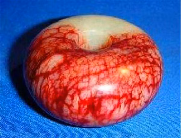 Năm ấy có một ngôi mộ cổ được phát hiện ở Mao Sơn, thuộc tỉnh Giang Tô (Trung Quốc). Trong lúc công tác khai quật mộ gần kết thúc, một người trong đoàn phát hiện có mảnh ngọc màu đỏ thẫm ở ngay dưới chân.