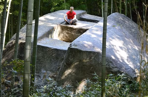 Mặt trên của nó đã được làm phẳng hoàn toàn và có hai lỗ hổng hình vuông dài 1 mét với một đường gờ song song. Ở chân tảng đá có những vết lõm hình mạng chưa rõ tác dụng.