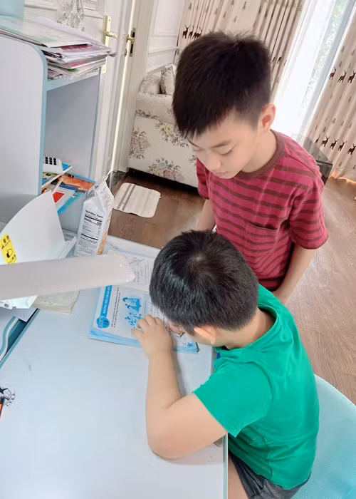 Bé Ken kèm cặp cậu em trai học hành.