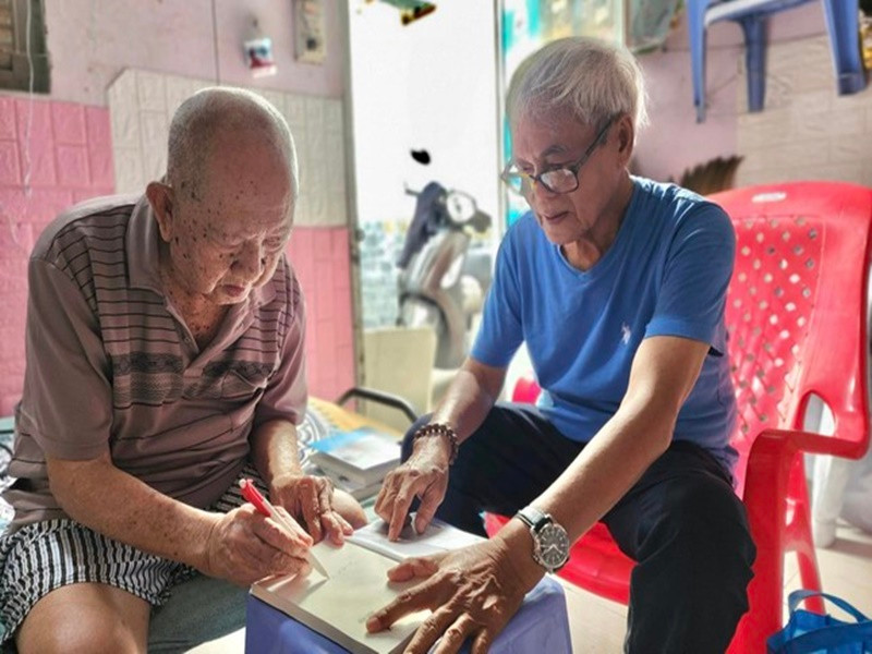 Nghệ sĩ Mạc Can và nhà văn Nguyễn Đông Thức ký tặng bạn đọc. Ảnh: Tiền Phong